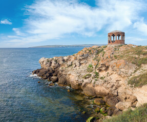 Rocky summer coastline and cape with pavilion