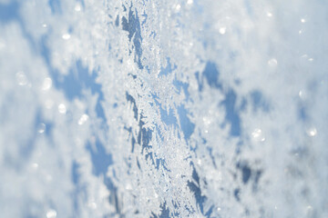 Obraz premium snow frost in the form of natural patterns on the window pane against the background of the morning sky