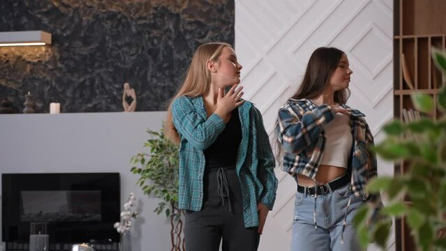 Pretty female teens recording a dance at home or in the studio for vlog. Young teenage women dancing hip hop. Two friends having fun together. High quality footage