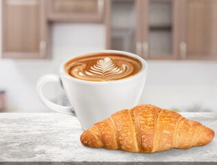 Tasty fresh baked croissant with cup