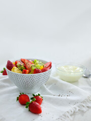 Mix fruit salad with yogurt on white background
