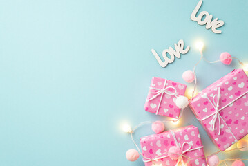 St Valentine's Day concept. Top view photo of gift boxes light bulb garland inscriptions love and fluffy pompons on isolated pastel blue background with empty space