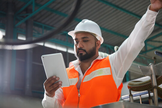 Professional Asian male engineer in helmet using the tablet to work, inspect and maintain electrical cabinet. Machines in a beverage factory, beverage industry concepts expert worker - Powered by Adobe