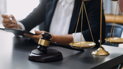 law books and scales of justice on desk in library of law firm. jurisprudence legal education concept.