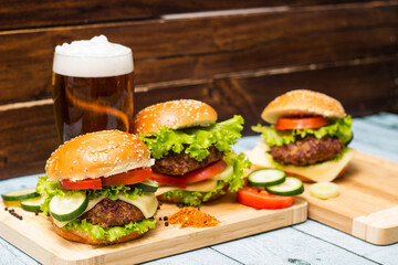 Burgers and beer on wooden background