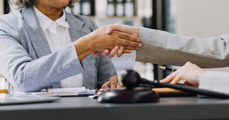 Business and lawyers discussing contract papers with brass scale on desk in office. Law, legal services, advice, justice and law concept picture with film grain effect