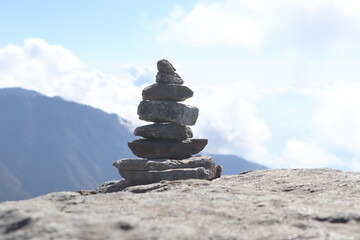 Pile of stones on ground against mountain landscape decoration on mountain top on summer day.