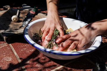 un cuoco prepara un intingolo con della carne e varie spezie in contesto esterno 