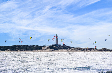People practicing kitesurfing on the beach of Los Caños de Meca, next to the Trafalgar Lighthouse, Barbate, Cádiz
