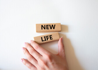 New life symbol. Wooden blocks with words New life. Beautiful white background. Businessman hand. Business and New life concept. Copy space.