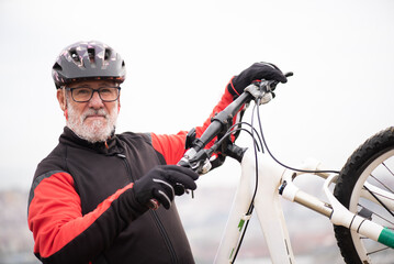 portrait of a retired older man dressed as a bicyclist riding his bike