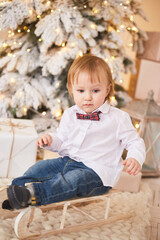 Fototapeta premium Smiling boy standing near christmas tree. Happy new year and merry Christmas.