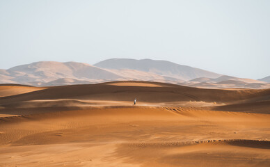 Fototapeta na wymiar Lonely walker in Sahara Desert Merzouga Person Morocco