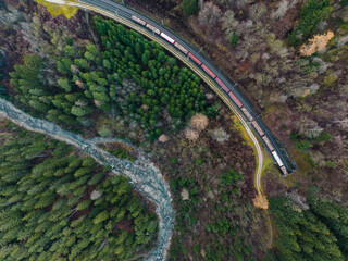 Railway tracks with train next to a creek