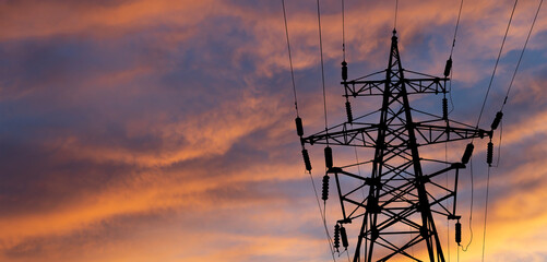 Electricity pylon (high voltage power line), black contour,  against the background of a romantic...