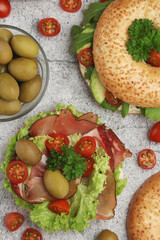 Sesame bagels with tomatoes, ham and olives	