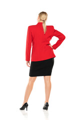 Fototapeta premium Middle aged senior business woman in red jacket and black skirt posing on white background. Back, rear view.