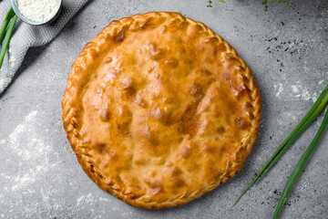 Ossetian pie with meat on grey table top view
