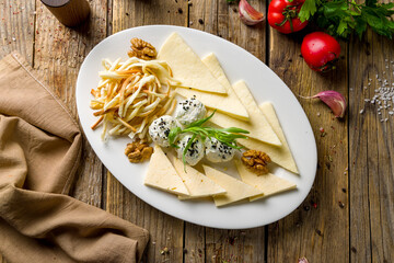 a plate of different Caucasian cheeses top view on wooden table