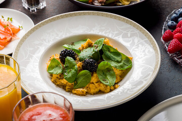 scramble with spinach and truffle on stone table