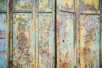 Rusty old metal door with peeling paint