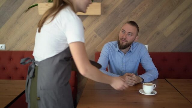Happy attractive woman waiter with good tip in restaurant.