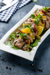 salad with duck and greens on a white plate  vertical