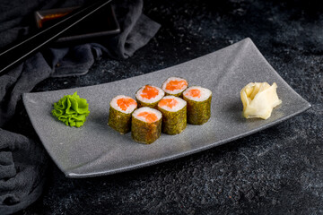 salmon roll on plate on dark table