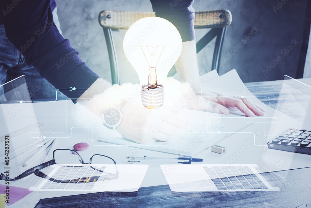 Poster View of Bulb lamp idea concept icon on a futuristic interface with writing man's hand background. Double exposure.