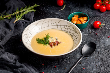 Soup cream of pumpkin with bacon on dark table