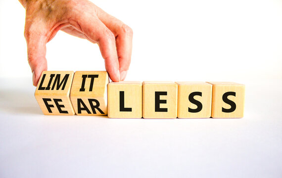 Fearless and limitless symbol. Concept word Fearless and limitless on wooden cubes. Businessman hand. Beautiful white table white background. Business fearless and limitless concept. Copy space.