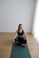 mulher linda fazendo alongamentos exercidios de yoga e meditação em casa 