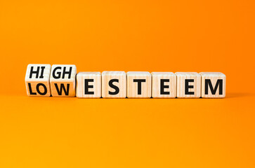 High or low esteem symbol. Concept words High esteem and Low esteem on wooden cubes. Beautiful orange table orange background. Business high or low esteem concept. Copy space.