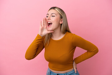 Young caucasian woman isolated on pink background shouting with mouth wide open to the side