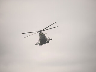 Fototapeta premium Military helicopter flying against a cloudy sky. Airshow demonstration.