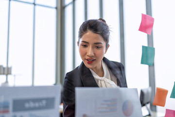 Employee meeting at office and use post it notes to share idea brainstorming stick on glass wall