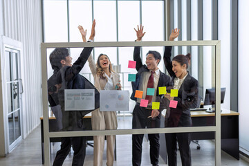 Employee meeting at office and use post it notes to share idea brainstorming stick on glass wall