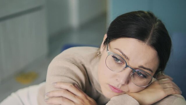 Young woman feeling sad and lonely, looking at window and dreaming, melancholy