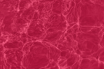 Transparent magenta water surface texture with ripples, splashes and bubbles. Abstract nature background Water waves in sunlight with copy space, 2023 color