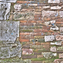 Italia, Perugia, estate 2022. Frammento di muro in mattoni e grandi pietre. Sul muro sono visibili tracce di vernice blu.