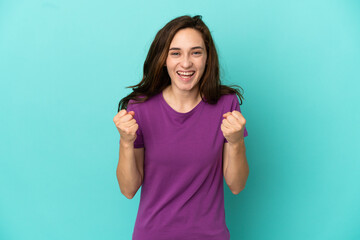 Fototapeta premium Young caucasian woman isolated on blue background celebrating a victory in winner position