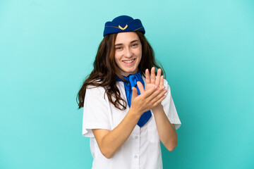 Airplane stewardess woman isolated on blue background applauding after presentation in a conference