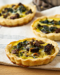 Spinach and morel mushroom quiche on a cloth napkin.