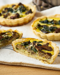Spinach and morel mushroom quiche on a cloth napkin.