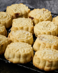Array of homemade mooncakes on a dark textured cloth.