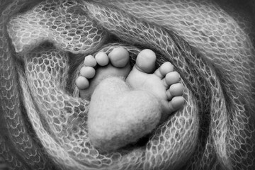  Knitted heart in the feet, legs of a newborn baby 