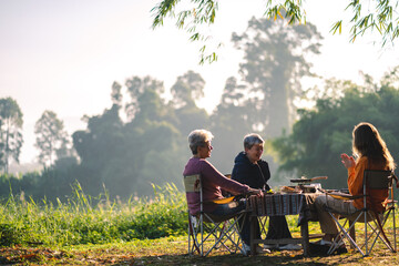 woman family having fun with food of picnic camp in the nature morning, summer travel vacation lifestyle of mother and girl at adventure forest park landscape in holiday, outdoors activity breakfast