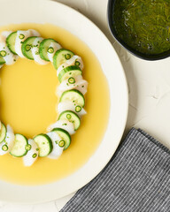 Scallop crudo with cucumber in bright yellow citrus sauce