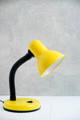 Bright yellow table lamp background concrete wall.