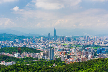 Overlooking view of the modern urban landscape of the Taipei area in Taiwan. It's a basin terrain surrounded by mountains.
